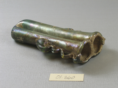 Roman. <em>Double Cosmetic Tube with Ribbon Handles</em>, 4th-6th century C.E. Glass, 7/8 × 1 1/8 × 2 1/2 in. (2.2 × 2.9 × 6.4 cm). Brooklyn Museum, Gift of Robert B. Woodward, 01.360. Creative Commons-BY (Photo: Brooklyn Museum, CUR.01.360_view4.jpg)