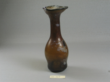 Roman. <em>Jug of Molded Amber Glass</em>, 4th-6th century C.E. Glass, 6 5/16 x diam. 2 3/8 in. (16 x 6.1 cm) . Brooklyn Museum, Gift of Robert B. Woodward, 01.367. Creative Commons-BY (Photo: Brooklyn Museum, CUR.01.367_view1.jpg)
