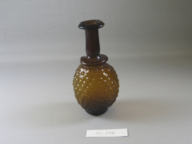 Roman. <em>Bottle with Stylized Grape Pattern</em>, 3rd century C.E. Glass, Greatest diam. 2 5/8 x 5 1/8 in. (6.6 x 13 cm). Brooklyn Museum, Gift of Robert B. Woodward, 01.372. Creative Commons-BY (Photo: Brooklyn Museum, CUR.01.372_view1.jpg)