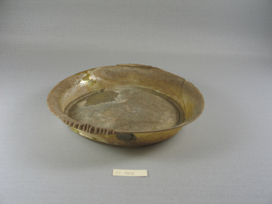 Roman. <em>Shallow Dish of Amber Glass</em>, Mid 2nd-mid 3rd century C.E. Glass, 1 7/8 x Diam. 8 1/4 in. (4.7 x 21 cm). Brooklyn Museum, Gift of Robert B. Woodward, 01.404. Creative Commons-BY (Photo: Brooklyn Museum, CUR.01.404_view1.jpg)