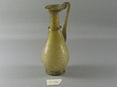 Roman. <em>Flask with Handle and Diagonal Ribs</em>, 3rd-4th century C.E. Glass, 6 5/8 x Diam. 2 1/2 in. (16.9 x 6.3 cm). Brooklyn Museum, Gift of Robert B. Woodward, 01.436. Creative Commons-BY (Photo: Brooklyn Museum, CUR.01.436_view1.jpg)