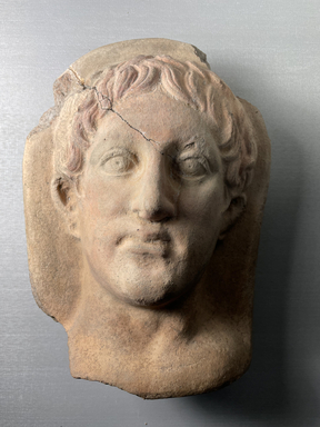 Possibly Greek. <em>Votive Head</em>, 3rd century-2nd century B.C.E. Clay, pigment, 10 5/8 × 7 × 1 in. (27 × 17.8 × 2.5 cm). Brooklyn Museum, Purchase gift of Robert B. Woodward and Carll H. de Silver, 04.16. Creative Commons-BY (Photo: Brooklyn Museum, CUR.04.16_view01.jpeg)