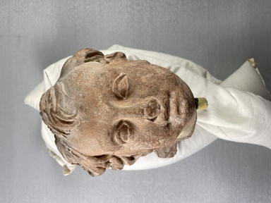 Roman. <em>Child's Head from a Statuette</em>, 17th century C.E. Clay, 4 15/16 × 4 15/16 in. (12.5 × 12.5 cm). Brooklyn Museum, Purchase gift of Robert B. Woodward and Carll H. de Silver, 04.22. Creative Commons-BY (Photo: Brooklyn Museum, CUR.04.22_view01.jpg)