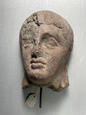 Etruscan. <em>Votive Mask of Coarse Red Clay</em>. Terracotta, 6 11/16 × 4 15/16 × 3 9/16 in. (17 × 12.5 × 9 cm). Brooklyn Museum, Purchase gift of Robert B. Woodward and Carll H. de Silver, 04.23. Creative Commons-BY (Photo: Brooklyn Museum, CUR.04.23_view01.jpeg)