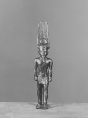  <em>Figure of Amon Standing on Small Oblong Base and Wearing the High Crown with Disk</em>, 305 B.C.E.-395 C.E. Bronze, 3 11/16 × 1/2 × 13/16 in. (9.3 × 1.2 × 2.1 cm). Brooklyn Museum, Charles Edwin Wilbour Fund, 05.374. Creative Commons-BY (Photo: , CUR.05.374_NegA_print_bw.jpg)