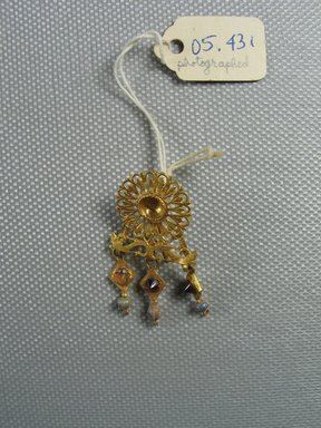 Roman. <em>Earring</em>, 3rd century C.E. Gold, garnet, glass, Diam. of rosette 9/16 x 3 1/4 in. (1.5 x 8.3 cm). Brooklyn Museum, Ella C. Woodward Memorial Fund, 05.431. Creative Commons-BY (Photo: Brooklyn Museum, CUR.05.431_overall.jpg)