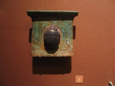  <em>Pectoral with Scarab</em>, ca. 1539–1295 B.C.E. or later. Faience, 4 1/16 x 3 11/16 x 3/8 in. (10.3 x 9.4 x 1 cm). Brooklyn Museum, Charles Edwin Wilbour Fund, 08.480.159. Creative Commons-BY (Photo: Brooklyn Museum, CUR.08.480.159_mummychamber.jpg)