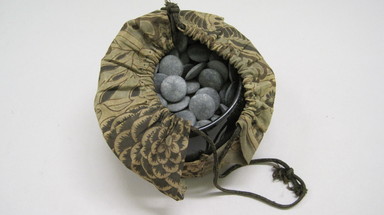  <em>Go (Game) with Case of 147 Pebbles and Bag</em>. Granite, lacquer case, and cotton bag Brooklyn Museum, Museum Expedition 1909, Purchased with funds given by Thomas T. Barr, E. LeGrand Beers, Carll H. de Silver, Herman B. Stutzer, Colonel Robert B. Woodward and the Museum Collection Fund, 09.931.1. Creative Commons-BY (Photo: , CUR.09.931.1_view01.jpg)