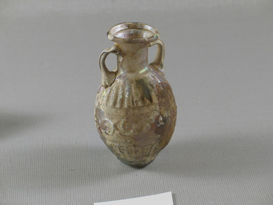 Roman. <em>Bulbous Bottle with Band of Scrolls</em>, 1st century C.E. Glass, 2 13/16 x 1 5/8 in. (7.1 x 4.2 cm). Brooklyn Museum, Gift of Aziz Khayat, 12.2. Creative Commons-BY (Photo: Brooklyn Museum, CUR.12.2_view1.jpg)