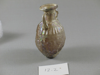 Roman. <em>Bulbous Bottle with Band of Scrolls</em>, 1st century C.E. Glass, 2 13/16 x 1 5/8 in. (7.1 x 4.2 cm). Brooklyn Museum, Gift of Aziz Khayat, 12.2. Creative Commons-BY (Photo: Brooklyn Museum, CUR.12.2_view3.jpg)