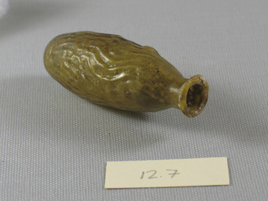 Roman. <em>Date-Shaped Bottle</em>, mid-1st to early 2nd century C.E. Glass, 3 x 1 Diam. 1/16 in. (7.6 x 2.7 cm). Brooklyn Museum, Gift of Aziz Khayat, 12.7. Creative Commons-BY (Photo: Brooklyn Museum, CUR.12.7_view3.jpg)