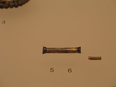  <em>Cylindrical Tube Amulet</em>, ca. 1938-1700 B.C.E. Ivory, 1/8 x 9/16 in. (0.4 x 1.4 cm). Brooklyn Museum, Gift of the Egypt Exploration Fund, 13.1039.1. Creative Commons-BY (Photo: , CUR.13.1038_13.1039.1_mummychamber.jpg)