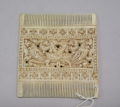 <em>Double-sided Comb</em>. Ivory, 3 1/8 x 2 3/4 in. (7.9 x 7 cm). Brooklyn Museum, Bequest of Robert B. Woodward, 14.460. Creative Commons-BY (Photo: , CUR.14.460.jpg)