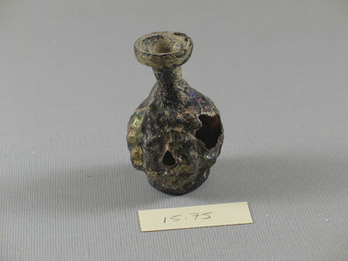 Roman. <em>Double Head-Shaped Flask</em>, 3rd century C.E. Glass, 2 3/8 x Diam. 1 7/16 in. (6 x 3.6 cm)  . Brooklyn Museum, Bequest of Robert B. Woodward, 15.75. Creative Commons-BY (Photo: Brooklyn Museum, CUR.15.75_view1.jpg)