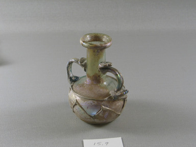Roman. <em>Two-Handled Bottle with Zigzag Trailing Decoration</em>, 2nd-3rd century C.E. Glass, 3 11/16 x 2 9/16 x 3 1/8 in. (9.3 x 6.5 x 7.9 cm). Brooklyn Museum, Bequest of Robert B. Woodward, 15.9. Creative Commons-BY (Photo: Brooklyn Museum, CUR.15.9_view2.jpg)