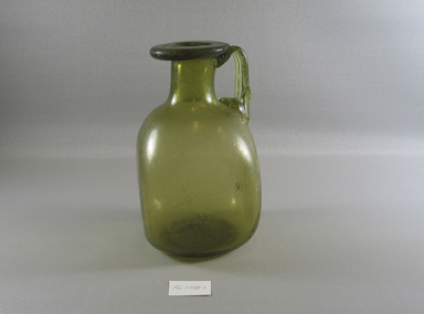  <em>Jug</em>, 4th century C.E. Glass, 7 7/8 x 4 5/16 x 4 7/16 in. (20 x 11 x 11.3 cm). Brooklyn Museum, Gift of Evangeline Wilbour Blashfield, Theodora Wilbour, and Victor Wilbour honoring the wishes of their mother, Charlotte Beebe Wilbour, as a memorial to their father, Charles Edwin Wilbour, 16.108.1. Creative Commons-BY (Photo: Brooklyn Museum, CUR.16.108.1_view1.jpg)