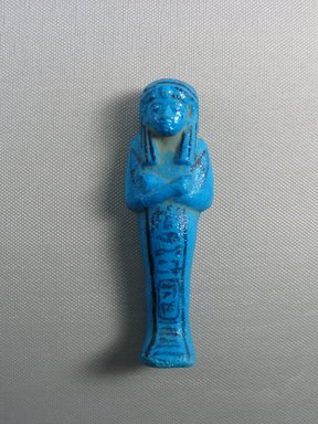 <em>Shabty of Pinodjem I</em>, ca. 1075-945 B.C.E. Faience, 4 1/8 × 1 3/8 in. (10.4 × 3.5 cm). Brooklyn Museum, Gift of Evangeline Wilbour Blashfield, Theodora Wilbour, and Victor Wilbour honoring the wishes of their mother, Charlotte Beebe Wilbour, as a memorial to their father, Charles Edwin Wilbour, 16.173. Creative Commons-BY (Photo: Brooklyn Museum, CUR.16.173_view01.jpg)