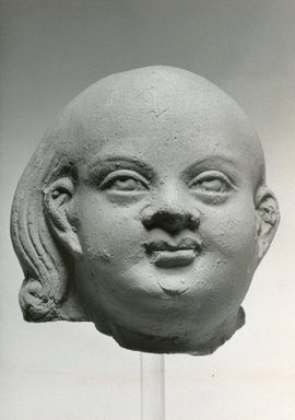  <em>Head of Harpocrates</em>, 2nd century C.E., or later. Terracotta, 2 5/8 x 2 11/16 x 2 3/4 in. (6.6 x 6.9 x 7 cm). Brooklyn Museum, Gift of Evangeline Wilbour Blashfield, Theodora Wilbour, and Victor Wilbour honoring the wishes of their mother, Charlotte Beebe Wilbour, as a memorial to their father, Charles Edwin Wilbour, 16.214. Creative Commons-BY (Photo: Brooklyn Museum, CUR.16.214_NegC_print_bw.jpg)