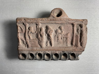  <em>Lamp</em>, 30 B.C.E.–100 C.E. Terracotta, 3 3/4 × 1 × 5 in. (9.5 × 2.5 × 12.7 cm). Brooklyn Museum, Gift of Evangeline Wilbour Blashfield, Theodora Wilbour, and Victor Wilbour honoring the wishes of their mother, Charlotte Beebe Wilbour, as a memorial to their father, Charles Edwin Wilbour, 16.311. Creative Commons-BY (Photo: Brooklyn Museum, CUR.16.311_view01.jpg)