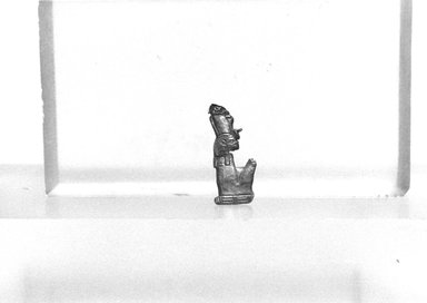  <em>Amulet in the Form of a Seated Mummified King</em>, ca. 1539-1075 B.C.E. Gold, 3/8 x 7/8 in. (0.9 x 2.3 cm) . Brooklyn Museum, Gift of Evangeline Wilbour Blashfield, Theodora Wilbour, and Victor Wilbour honoring the wishes of their mother, Charlotte Beebe Wilbour, as a memorial to their father, Charles Edwin Wilbour, 16.323. Creative Commons-BY (Photo: Brooklyn Museum, CUR.16.323_NegL1005_8_print_bw.jpg)