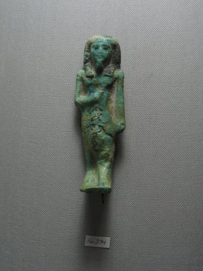  <em>Ushabti</em>, ca. 1075-712 B.C.E. Faience, 4 9/16 x 1 7/16 x 1 7/16 in. (11.6 x 3.7 x 3.7 cm). Brooklyn Museum, Gift of Evangeline Wilbour Blashfield, Theodora Wilbour, and Victor Wilbour honoring the wishes of their mother, Charlotte Beebe Wilbour, as a memorial to their father, Charles Edwin Wilbour, 16.374. Creative Commons-BY (Photo: Brooklyn Museum, CUR.16.374_view1.jpg)