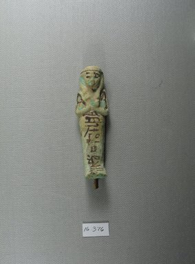  <em>Ushabti</em>, ca. 1075–656 B.C.E. Faience, height: 3 11/16 in. (9.3 cm); width: 1 1/8 in. (2.9 cm). Brooklyn Museum, Gift of Evangeline Wilbour Blashfield, Theodora Wilbour, and Victor Wilbour honoring the wishes of their mother, Charlotte Beebe Wilbour, as a memorial to their father, Charles Edwin Wilbour, 16.376. Creative Commons-BY (Photo: Brooklyn Museum, CUR.16.376_view1.jpg)