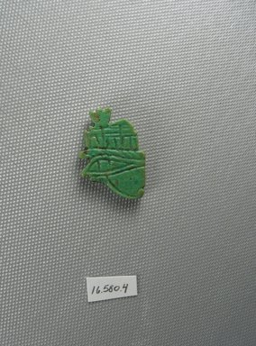  <em>Wadjet-eye Amulet</em>, 664-525 B.C.E. Faience, 1 1/4 x 3/16 x 7/8 in. (3.1 x 0.5 x 2.3 cm). Brooklyn Museum, Gift of Evangeline Wilbour Blashfield, Theodora Wilbour, and Victor Wilbour honoring the wishes of their mother, Charlotte Beebe Wilbour, as a memorial to their father Charles Edwin Wilbour, 16.580.4. Creative Commons-BY (Photo: Brooklyn Museum, CUR.16.580.4_view2.jpg)