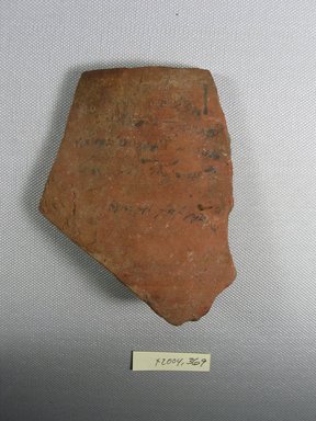 Demotic. <em>Ostracon with Demotic and Greek Writing</em>, Year 26 of Augustus. Terracotta, pigment, 3 7/16 x 3/8 x 4 3/8 in. (8.8 x 0.9 x 11.1 cm). Brooklyn Museum, Gift of Evangeline Wilbour Blashfield, Theodora Wilbour, and Victor Wilbour honoring the wishes of their mother, Charlotte Beebe Wilbour, as a memorial to their father, Charles Edwin Wilbour, 16.580.580. Creative Commons-BY (Photo: Brooklyn Museum, CUR.16.580.580_view1.jpg)