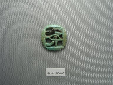  <em>Wadjet-eye Amulet</em>. Faience, 1 1/8 x 1/4 x 1 1/16 in. (2.9 x 0.6 x 2.7 cm). Brooklyn Museum, Gift of Evangeline Wilbour Blashfield, Theodora Wilbour, and Victor Wilbour honoring the wishes of their mother, Charlotte Beebe Wilbour, as a memorial to their father Charles Edwin Wilbour, 16.580.62. Creative Commons-BY (Photo: Brooklyn Museum, CUR.16.580.62_view1.jpg)