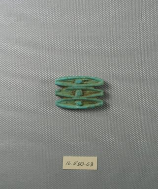  <em>Triple Wadjet-eye Amulet</em>. Faience, 1 5/16 x 1/4 x 1 1/4 in. (3.3 x 0.6 x 3.1 cm). Brooklyn Museum, Gift of Evangeline Wilbour Blashfield, Theodora Wilbour, and Victor Wilbour honoring the wishes of their mother, Charlotte Beebe Wilbour, as a memorial to their father Charles Edwin Wilbour, 16.580.63. Creative Commons-BY (Photo: Brooklyn Museum, CUR.16.580.63_view1.jpg)