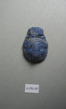  <em>Lion Head or Mask as Amulet?</em>. Glass, 1 7/8 x Diam. 1 5/16 in. (4.7 x 3.4 cm). Brooklyn Museum, Gift of Evangeline Wilbour Blashfield, Theodora Wilbour, and Victor Wilbour honoring the wishes of their mother, Charlotte Beebe Wilbour, as a memorial to their father Charles Edwin Wilbour, 16.580.86. Creative Commons-BY (Photo: Brooklyn Museum, CUR.16.580.86_View1.jpg)