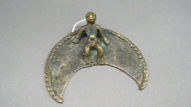 Nuna. <em>Pectoral Pendant of a Crescent and a Stylized Human Figure</em>, late 19th-early 20th century. Cast copper alloy, 3 1/2 x 3 3/4 x 1/8 in. (8.9 x 9.5 x 0.3 cm). Brooklyn Museum, Gift of Mrs. Carl L. Selden in honor of Ruth Lippman, 1993.1. Creative Commons-BY (Photo: Brooklyn Museum, CUR.1993.1.jpg)