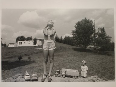 Sage Sohier (American, born 1954). <em>T.C. Buckhannon, West Virginia (Girl with Toys with Boy Admirer)</em>, 1982. Gelatin silver print, image: 12 1/4 x 15 3/4 in. (31.2 x 40.1 cm). Brooklyn Museum, Gift of the artist, 1997.55.1. © artist or artist's estate (Photo: Brooklyn Museum, CUR.1997.55.1.jpg)
