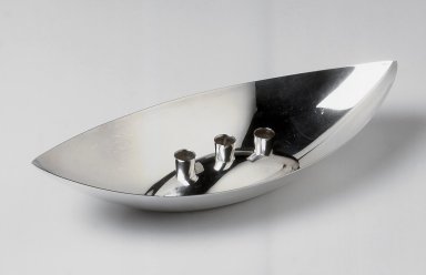 Gorham Manufacturing Company (1865–1961). <em>Centerpiece with Candle Holder, Bateau Pattern</em>, ca. 1960. Silverplate, 2 1/2 x 12 1/8 x 5 3/8 in. (6.4 x 30.8 x 13.7 cm). Brooklyn Museum, Gift of Jewel Stern, 2004.12.15a-b. Creative Commons-BY (Photo: Brooklyn Museum, CUR.2004.12.15a-b.jpg)