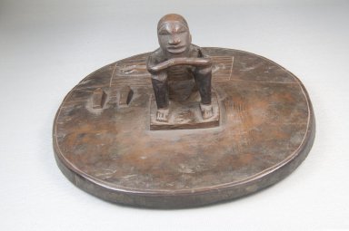 Woyo. <em>Pot Lid with Seated Male Figure (Taampha)</em>, 19th or early 20th century. Wood, stain, 3 1/2 x 8 x 8 in. (8.9 x 20.3 x 20.3 cm). Brooklyn Museum, Museum Expedition 1922, Robert B. Woodward Memorial Fund, 22.1115. Creative Commons-BY (Photo: Brooklyn Museum, CUR.22.1115_front_PS5.jpg)