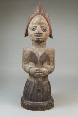 Yorùbá. <em>Figure of a Devotee of Shango Holding an Oshe Shango</em>, late 19th or early 20th century. Wood, pigment, 15 x 4 15/16 x 5 3/4 in. (38.1 x 12.5 x 14.6 cm). Brooklyn Museum, Museum Expedition 1922, Robert B. Woodward Memorial Fund, 22.1518. Creative Commons-BY (Photo: Brooklyn Museum, CUR.22.1518_front_PS5.jpg)