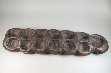 Possibly Tuareg. <em>Mancala Game Board</em>, late 19th century. Wood, 1 1/2 x 19 1/2 x 5 1/4 in. Brooklyn Museum, Museum Expedition 1922, Robert B. Woodward Memorial Fund, 22.201. Creative Commons-BY (Photo: Brooklyn Museum, CUR.22.201_top_PS5.jpg)