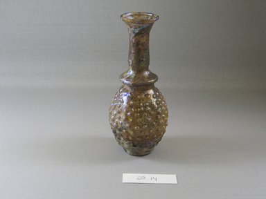 Roman. <em>Bottle with Stylized Grape Pattern</em>, 3rd century C.E. Glass, Greatest diam.  2 5/16 x 5 11/16 in. (5.9 x 14.5 cm). Brooklyn Museum, Brooklyn Museum Collection, 23.14. Creative Commons-BY (Photo: Brooklyn Museum, CUR.23.14_view1.jpg)
