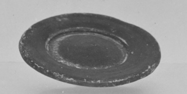 Attic. <em>Miniature Plate</em>, 4th century B.C.E. (probably). Clay, slip, 3/16 x Diam. 1 9/16 in. (0.5 x 4 cm). Brooklyn Museum, Charles Edwin Wilbour Fund, 34.727. Creative Commons-BY (Photo: Brooklyn Museum, CUR.34.727_print_cropped_bw.jpg)