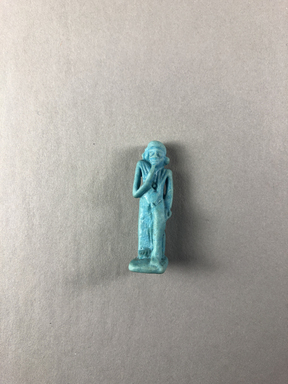  <em>Amulet of the Child Horus</em>, 664–332 B.C.E. Faience, 1 5/8 × 1/2 × 9/16 in. (4.1 × 1.3 × 1.4 cm). Brooklyn Museum, Charles Edwin Wilbour Fund, 37.1094E. Creative Commons-BY (Photo: , CUR.37.1094E_view01.jpg)