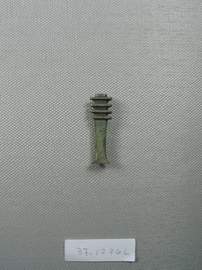  <em>Djed-pillar Amulet</em>, 664–332 B.C.E. Faience, 1 7/16 x 7/16 x 1/4 in. (3.6 x 1.2 x 0.7 cm). Brooklyn Museum, Charles Edwin Wilbour Fund, 37.1276E. Creative Commons-BY (Photo: Brooklyn Museum, CUR.37.1276E_overall.jpg)