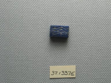  <em>Bes and Wadjet-eye Plaque</em>, 664–332 B.C.E. Faience or glazed steatite, 3/16 x 3/8 x 9/16 in. (0.5 x 0.9 x 1.4 cm). Brooklyn Museum, Charles Edwin Wilbour Fund, 37.1337E. Creative Commons-BY (Photo: Brooklyn Museum, CUR.37.1337E_view1.jpg)