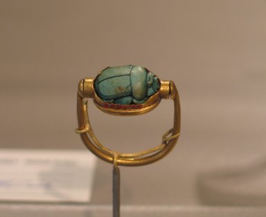  <em>Scarab of Thutmose III Mounted in Ring</em>, ca. 1479–1425 B.C.E. Steatite, glaze, gold, 1/2 × 15/16 × 1 3/16 in. (1.3 × 2.4 × 3 cm). Brooklyn Museum, Charles Edwin Wilbour Fund, 37.720E. Creative Commons-BY (Photo: Brooklyn Museum, CUR.37.720E_erg456.jpg)