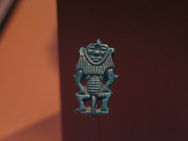  <em>Bes-Image Amulet</em>, ca. 1539–1478 B.C.E. Faience, 1 3/16 × 5/8 × 3/16 in. (3 × 1.6 × 0.5 cm). Brooklyn Museum, Charles Edwin Wilbour Fund, 37.914E. Creative Commons-BY (Photo: Brooklyn Museum, CUR.37.914E_erg2.jpg)