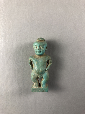  <em>Amulet of Pataikos</em>, 664–332 B.C.E. Faience, 1 15/16 × 7/8 × 11/16 in. (5 × 2.3 × 1.8 cm). Brooklyn Museum, Charles Edwin Wilbour Fund, 37.986E. Creative Commons-BY (Photo: , CUR.37.986E_view01.jpg)