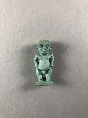  <em>Amulet of Pataikos</em>, 664-332 B.C.E. Faience, 1 1/2 × 11/16 × 1/2 in. (3.8 × 1.8 × 1.3 cm). Brooklyn Museum, Charles Edwin Wilbour Fund, 37.988E. Creative Commons-BY (Photo: , CUR.37.988E_view01.jpg)
