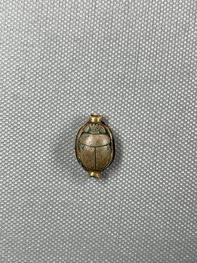  <em>Scarab of Tjuia in Setting</em>. Steatite, glaze, gold, 1/4 x 1/2 x 9/16 in. (0.7 x 1.2 x 1.5 cm). Brooklyn Museum, Charles Edwin Wilbour Fund, 44.123.101. Creative Commons-BY (Photo: Brooklyn Museum, CUR.44.123.101_overall.JPG)