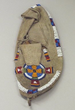 Blackfoot. <em>Child's Moccasin with Beaded Cross and Circle Design</em>, 1930s. Beads, sinew, cotton thread, 8 7/8 x 3 3/4 in. (22.5 x 9.5 cm). Brooklyn Museum, Gift of Mr. and Mrs. Jerome Blum, 66.86.25. Creative Commons-BY (Photo: Brooklyn Museum, CUR.66.86.25_view1.jpg)