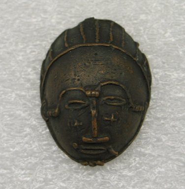 Akan. <em>Gold-weight (abrammuo): mask</em>. Brass, 1 7/8 x 1 3/8 x 11/16 in. (4.8 x 3.5 x 1.7 cm). Brooklyn Museum, Bequest of Laura L. Barnes, 67.25.6. Creative Commons-BY (Photo: Brooklyn Museum, CUR.67.25.6_front.jpg)