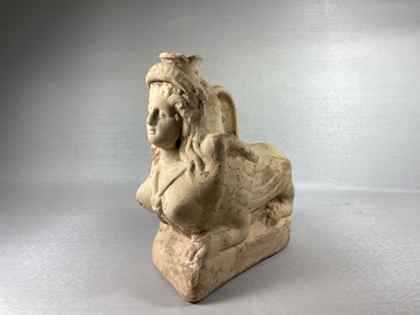 Etruscan. <em>Vessel in the Form of a Female Sphinx</em>, 2nd to 1st century B.C.E. Clay, slip, 7 1/2 × 3 7/8 × 6 7/8 in. (19 × 9.8 × 17.5 cm). Brooklyn Museum, Charles Edwin Wilbour Fund, 70.58. Creative Commons-BY (Photo: Brooklyn Museum, CUR.70.58_view01.jpg)